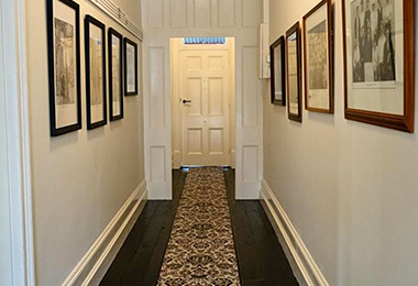 Period hallway entrance lined with historical photos.
